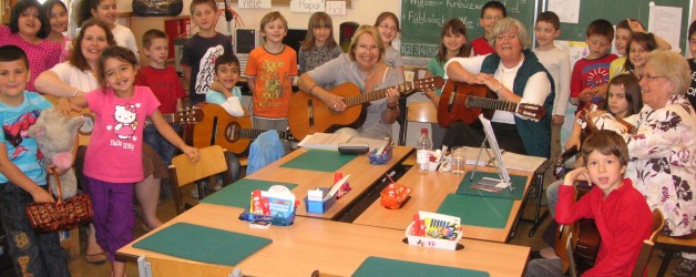 Alt und Jung spielen gemeinsam Gitarre